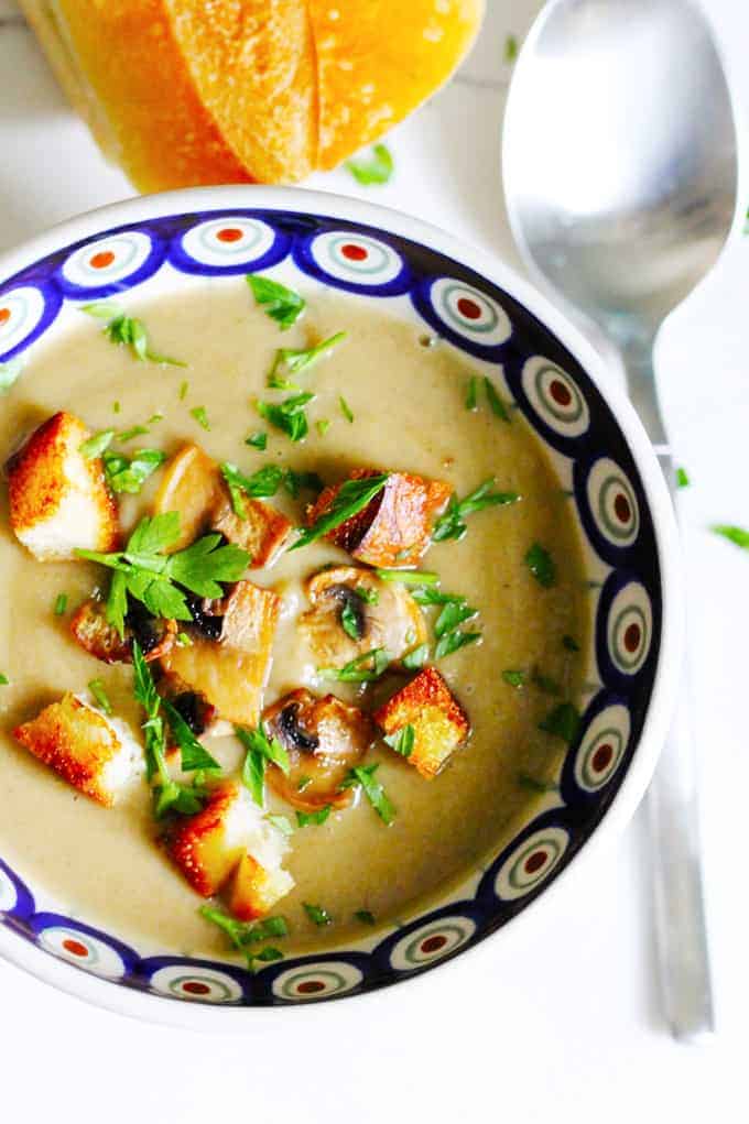 Creamy mushroom soup with croutons in a blue bowl