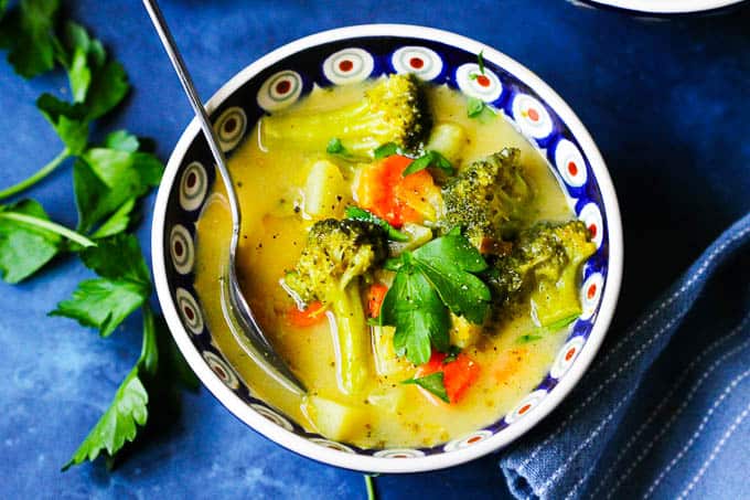 An overhead picture of Broccoli Leek Potato Soup in a colorful bowl with spoon