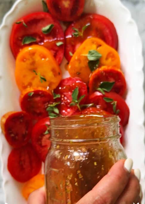 Dressing is poured over the heirloom tomato salad 
