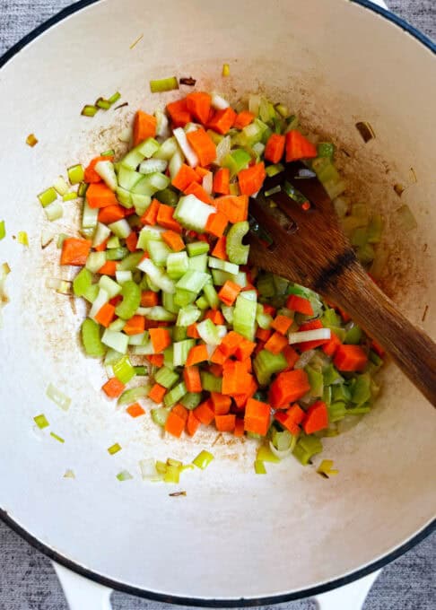 Stirring carrots and celery into the pot
