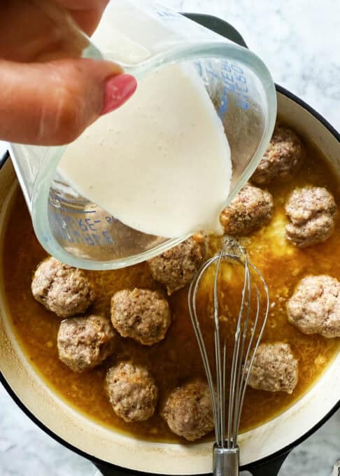 Pouring cream and flour mixture over the boiling meatballs