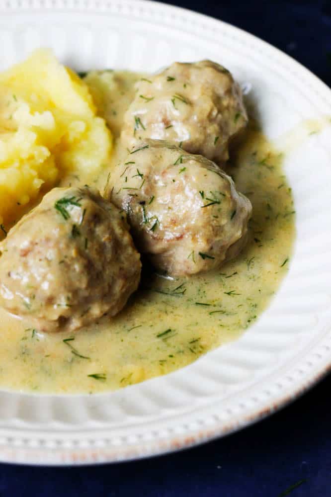 Closeup of boiled meatballs and sauce on a plate