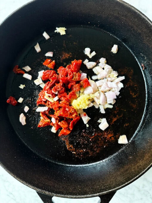 Cooking shallots, garlic, and tomatoes