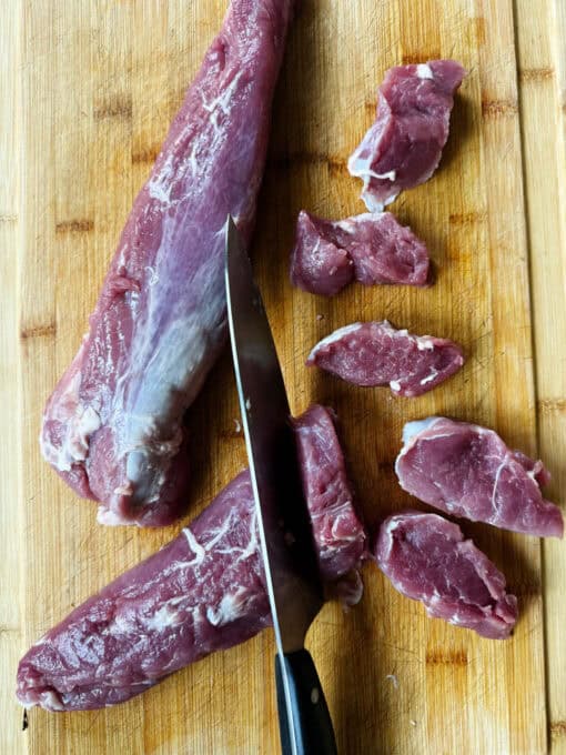 Cutting the pork medallions into slices on a chopping board