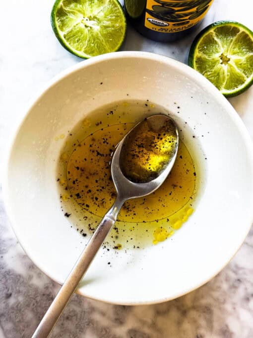 Making the salad dressing in  small white bowl