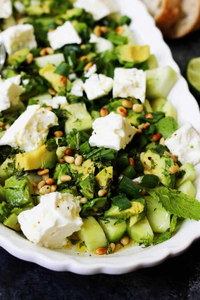Closeup of cucumber and feta salad drizzled with dressing