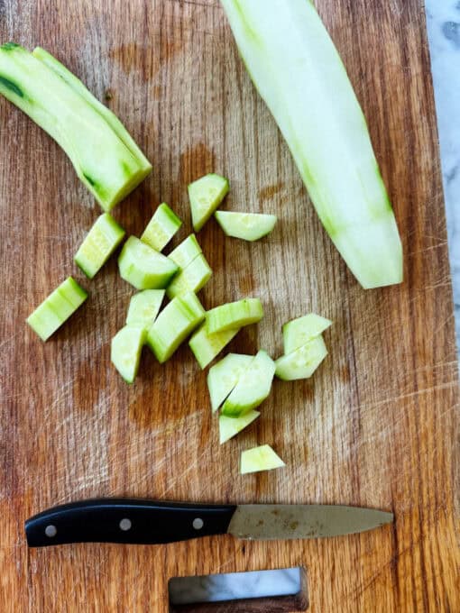 A cucumber cut into rounds on a chopping board