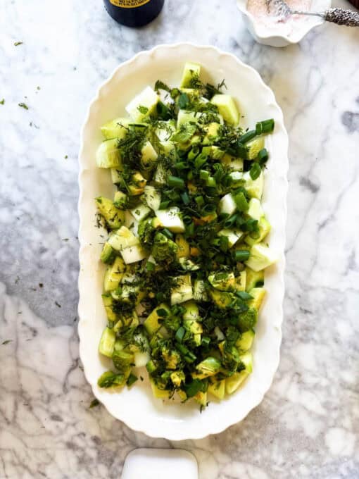Herbs and scallions are added to the cucumber feta salad