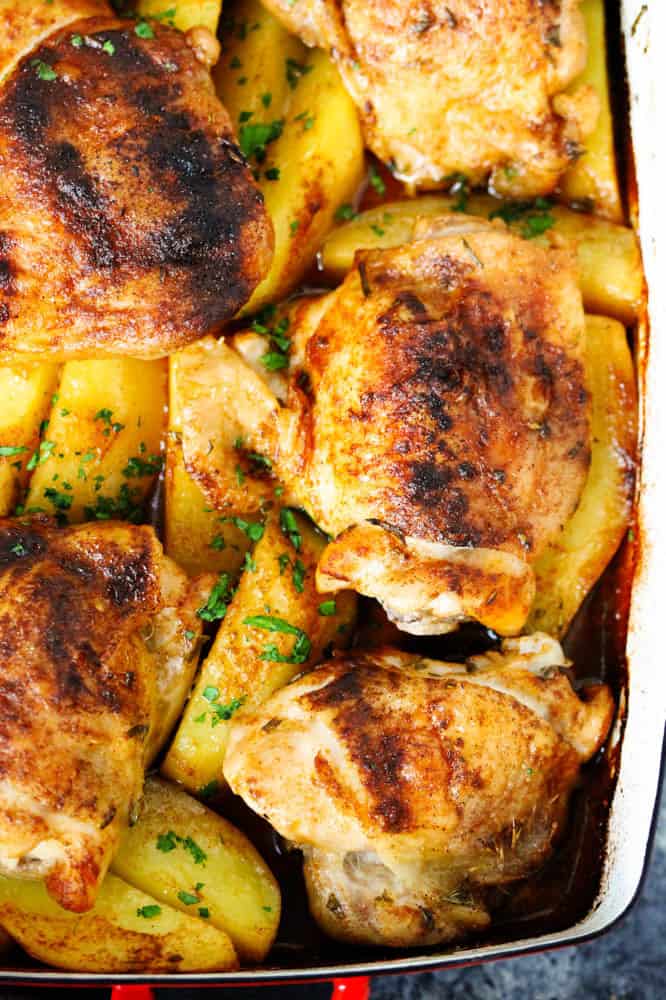 Oven roasted chicken thighs and potatoes in a roasting dish