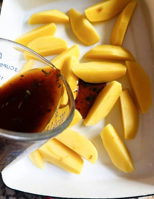 Marinade being poured over the potatoes