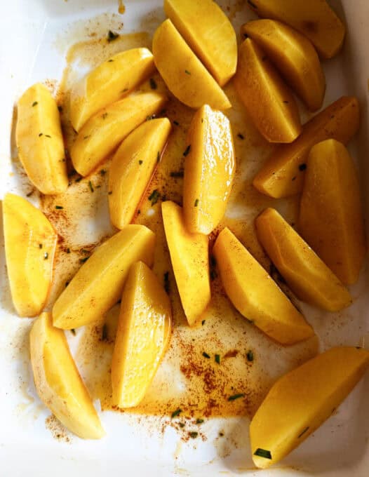 Potatoes mixed with the marinade in the oven dish