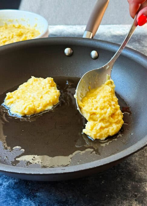 Potato mixture is spooned into a pan of hot oil