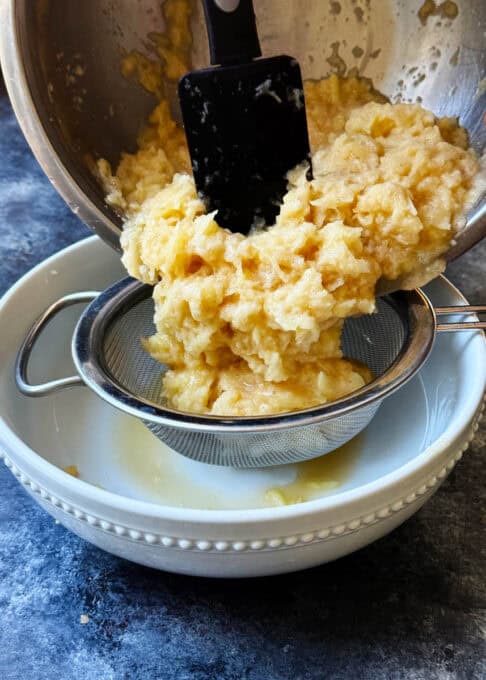 Grated potatoes are placed in a colander