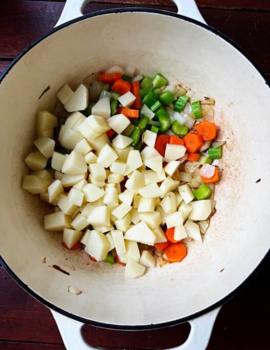 Onions, carrots, celery, and potatoes in the pot
