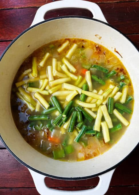 Yellow and green beans added to the soup pot