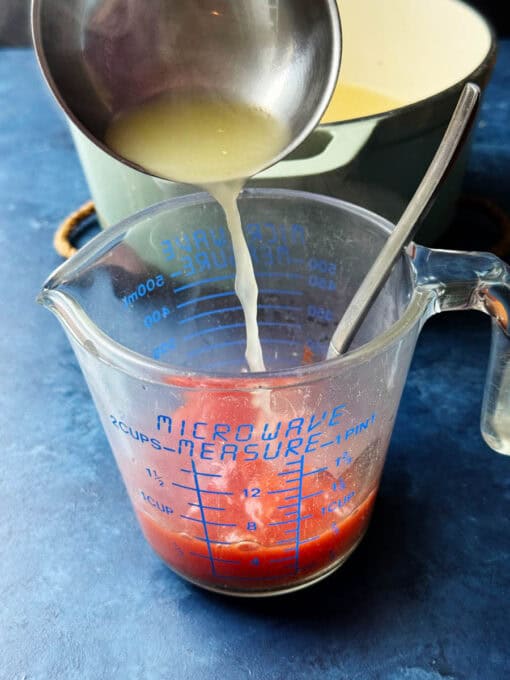 Pouring chicken broth into tomato paste