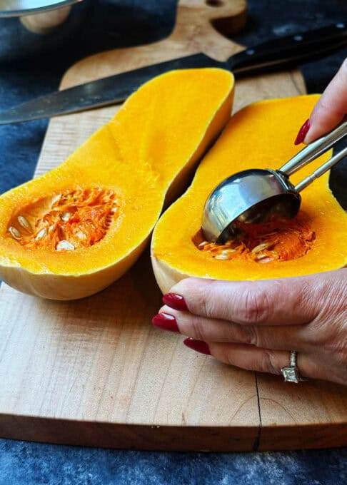 Scooping out butternut squash seeds