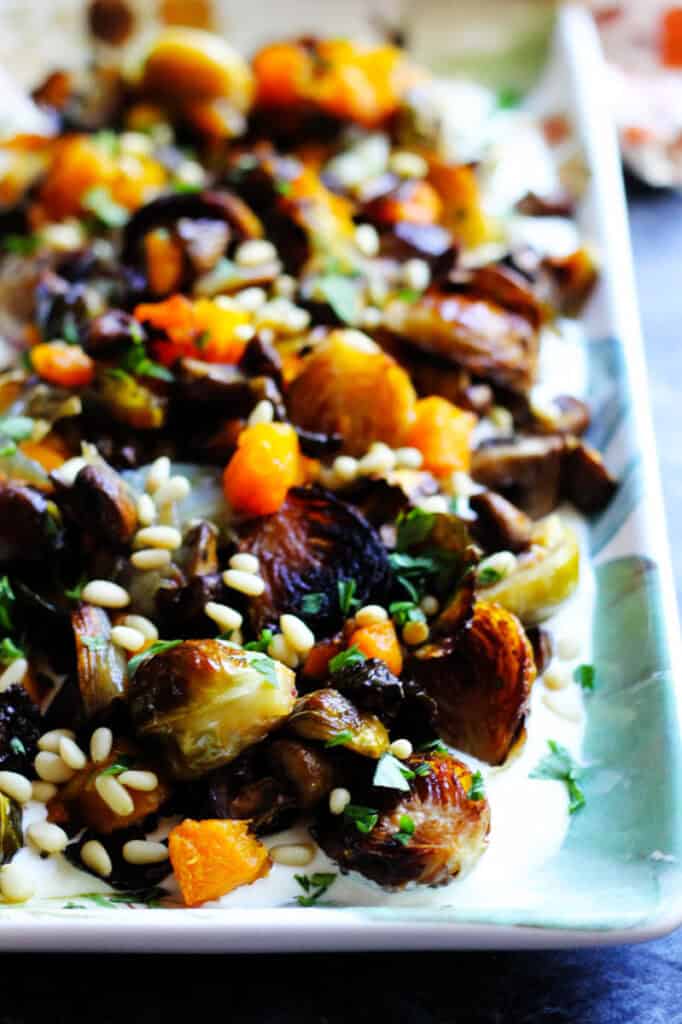 Close up of roasted fall vegetables and whipped feta on a plate
